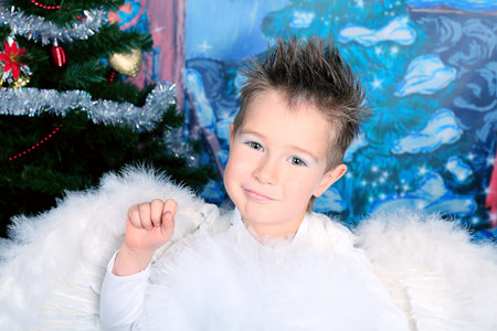 Beautiful little angel boy over Christmas background.の写真素材