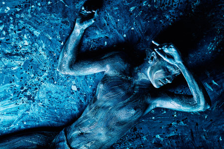 Portrait of an artistic woman painted with clay. Shot in a studio. の写真素材