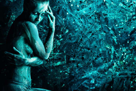 Portrait of an artistic woman painted with clay. Shot in a studio. の写真素材