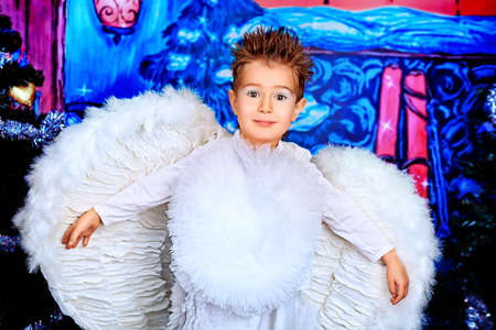 Beautiful little angel boy over Christmas background.の写真素材