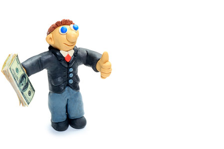 Shot of a plasticine businessman in a suit holding money. Isolated over white background.