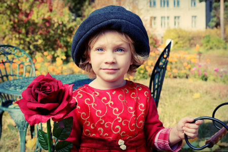 Cute little girl having a rest at a park. Retro style.の写真素材