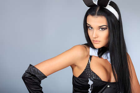 Sexy playgirl in bunny costume over grey background.の写真素材