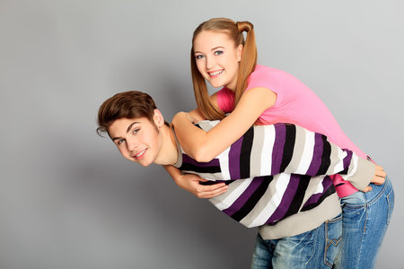 Happy smiling couple in love.  Over grey background.