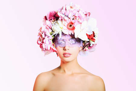 Portrait of a beautiful spring girl wearing flowers hat. Studio shot.の写真素材