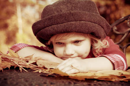 Cute little girl having a rest at a park. Retro style.の写真素材