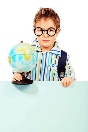 Portrait of a little boy in spectacles with globe. Isolated over white background.の写真素材