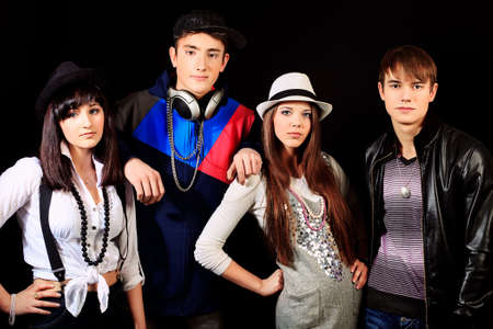 Group of stylish young people posing over black background. の写真素材