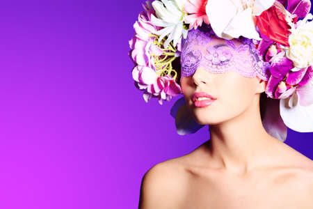 Portrait of a beautiful spring girl wearing flowers hat. Studio shot.の写真素材