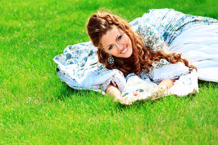 Beautiful young woman in medieval era dress on a sunny day outdoor.の写真素材