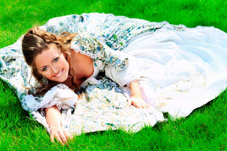 Beautiful young woman in medieval era dress on a sunny day outdoor.の写真素材