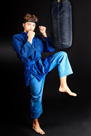 Martial arts fighter posing at studio.