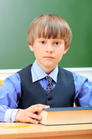 Portrait of a cute schoolboy in a classroom.の写真素材
