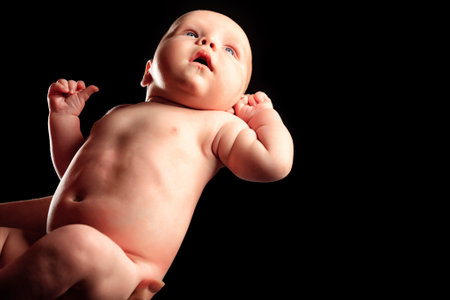 Mother's hands tenderly hold their newborn baby.