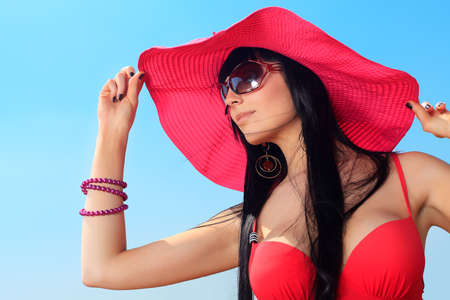 Beautiful young woman in bikini over blue sky.の写真素材