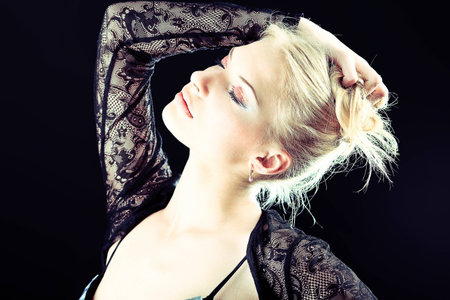 Portrait of a beautiful blonde woman. Studio shot over black background.の写真素材