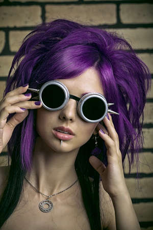 Portrait of a punk girl posing over brick wall.の写真素材