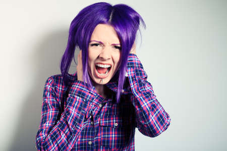 Portrait of a shouting punk girl with purple hair. の写真素材