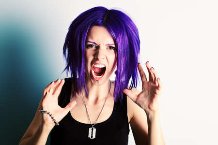 Portrait of a aggressive punk girl with purple hair. の写真素材