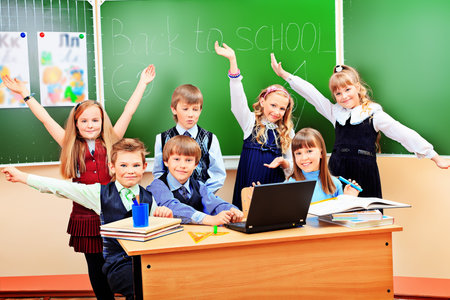 Happy schoolchildren at a classroom. Education.