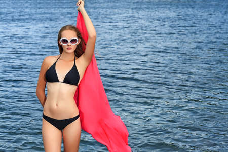 Romantic beautiful woman sunbathing on a seaside.の写真素材