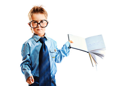 Little boy in spectacles and suit standing with opened diary. Isolated over white background.