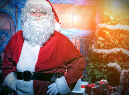 Santa Claus posing with presents over Christmas background.の写真素材