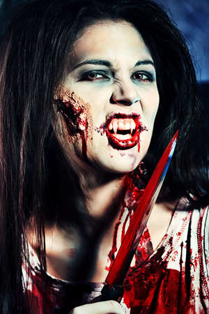 Bloodthirsty zombi standing at the night cemetery in the mist and moonlight.の写真素材