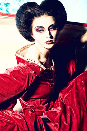 Bloodthirsty female vampire rises from the coffin on the night cemetery.