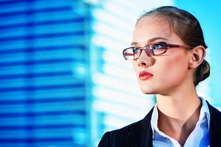 Young business woman standing in the big city and purposefully looking away.の写真素材