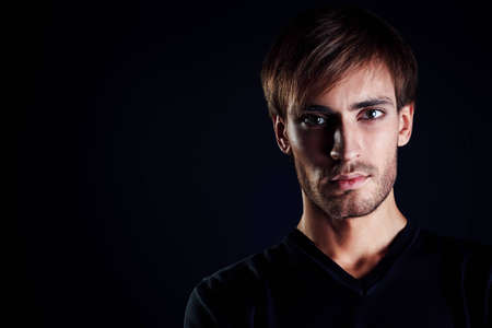 Portrait of a handsome man over black background.の写真素材