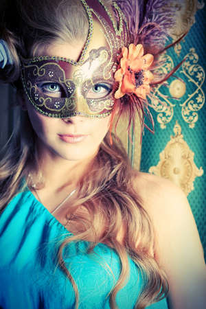 Portrait of a beautiful young woman in a carnival mask. Vintage style.の写真素材