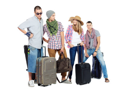 Group of cheerful young people standing together with suitcases over white background.の写真素材