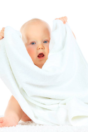Portrait of beautiful small baby sitting with a towel. Isolated over white.の写真素材