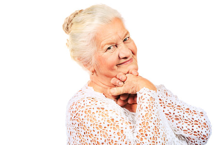 Happy senior woman smiling at the camera. Isolated over white.
