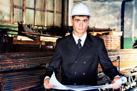 An architecture is working at a manufacturing area.
