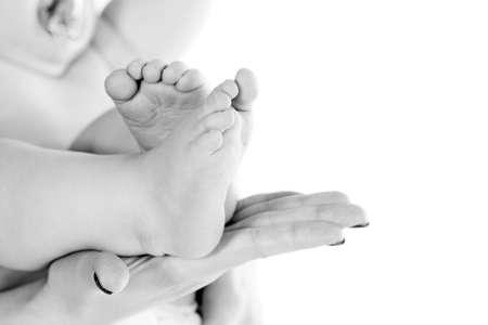 Baby in his mother's gentle hands. Isolated over white.の写真素材