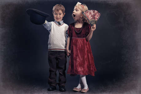 Cute little boy gentleman standing with the charming little lady. Retro style.の写真素材