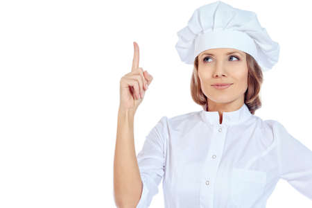 Smiling cook woman drawing attention to something important.  Isolated over white background.の写真素材