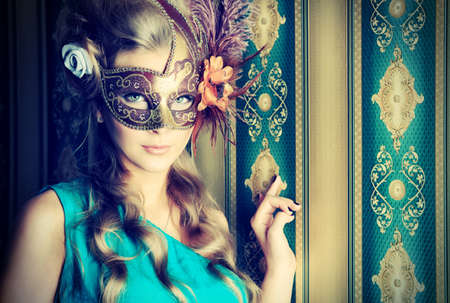 Portrait of a beautiful young woman in a carnival mask. Vintage style.の写真素材