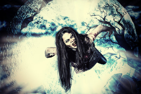 Bloodthirsty vampire flying at the night cemetery in the mist and moonlight.