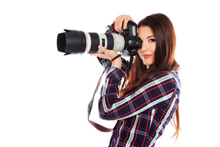 Pretty young woman taking pictures on the camera. Isolated over white.
