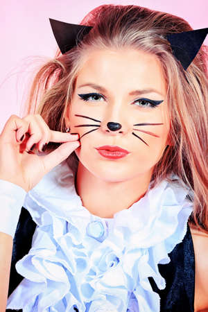 Portrait of a sexy playgirl in pussycat costume alluring over pink background.の写真素材