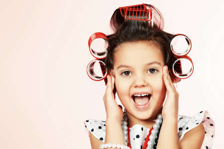 Portrait of a cute emotional little pin-up girl over pink background.の写真素材