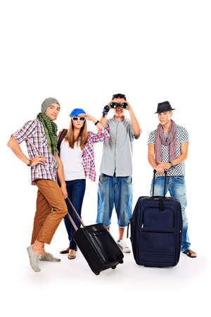 Group of cheerful young people standing together with suitcases over white background.の写真素材