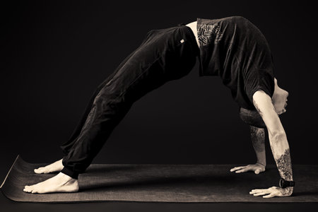 Handsome man shows different yoga exercises over black background.