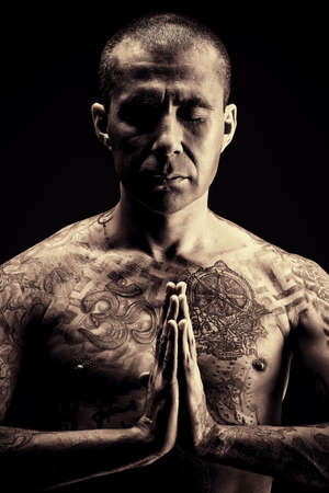 Handsome man shows different yoga exercises over black background.の写真素材