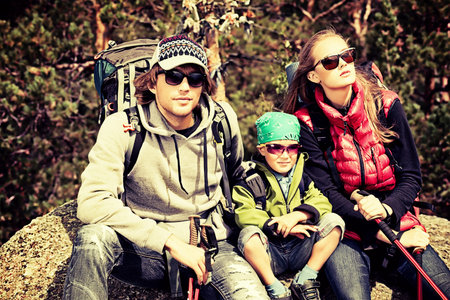 Happy parents hiking with their little son.