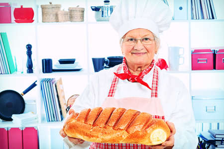 Senior woman chef cooks in the kitchen.の写真素材