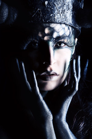 Close-uo portrait of a beautiful and scary devil woman. Art project.